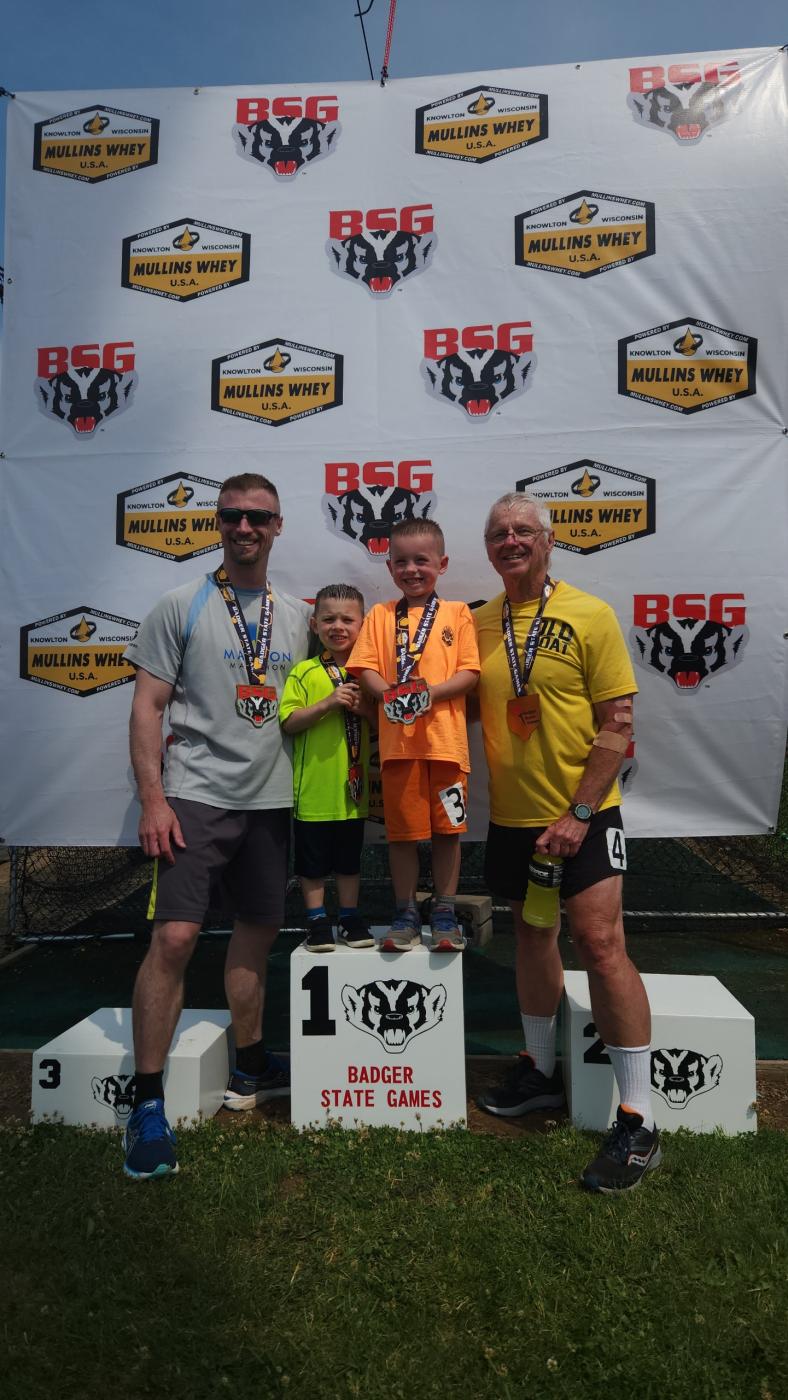 Eugene with his dad and two sons after running a multi-generational relay at the Wisconsin Badger State Games Track & Field Competition in 2023, and have repeated this tradition annually.