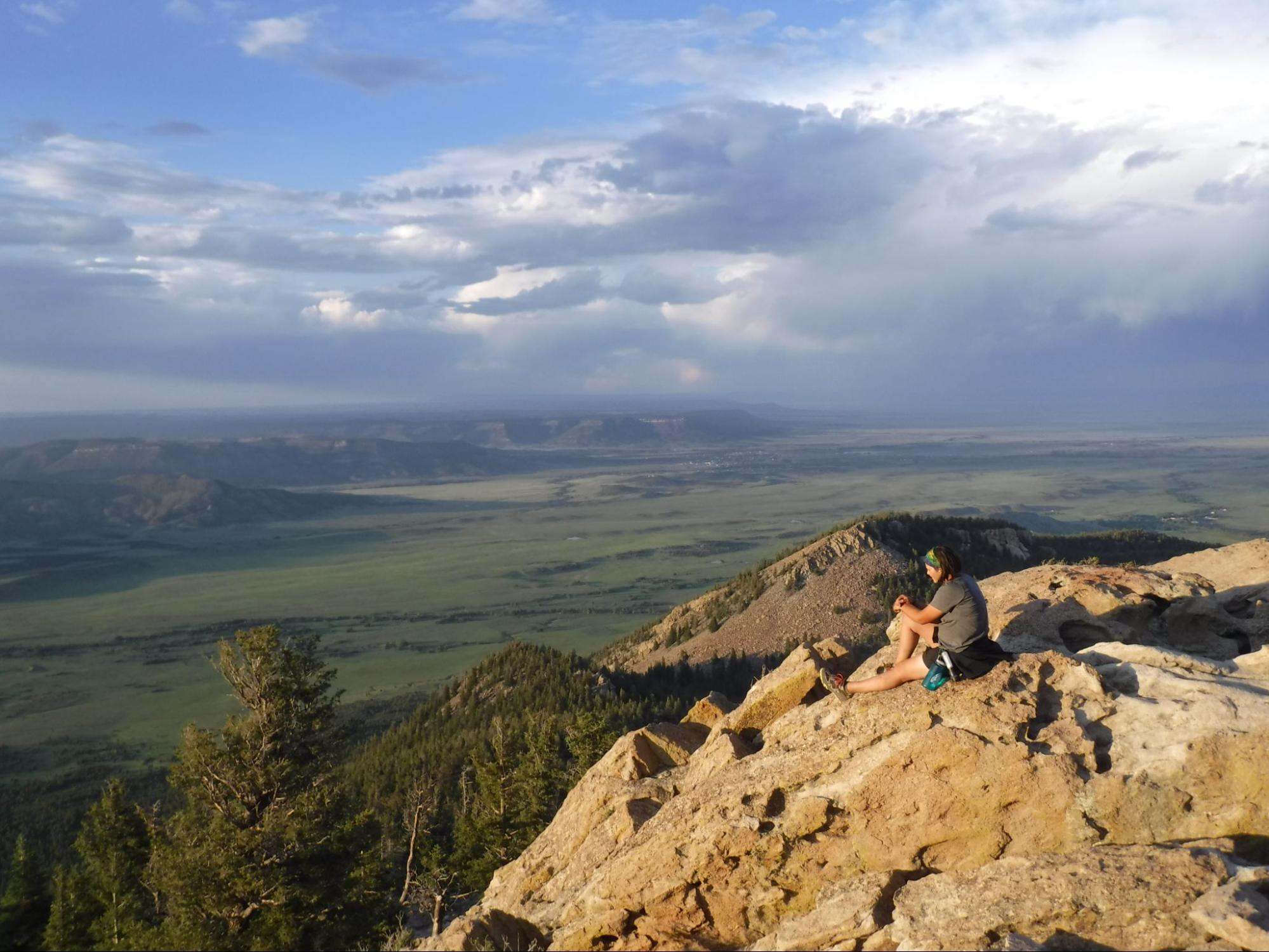 Sarah sits on a mountain